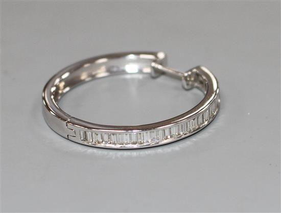 A modern single 14k white metal and baguette cut diamond set hoop earring, width 30mm, gross 5 grams.